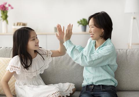 Happy Asian Woman And Girl Playing High Five At Home, Smiling Together, Family
