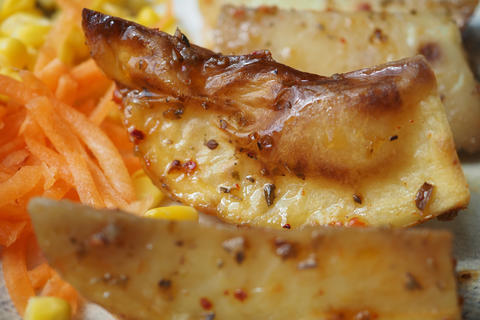 Sliced cooked vegetable dish with side of salad