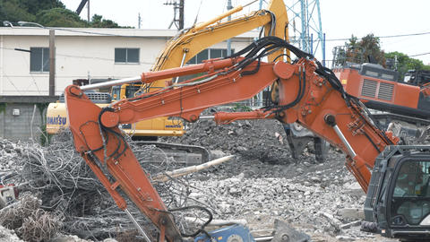 Multiple pieces of heavy machinery operating at a demolition site [Vertical video]