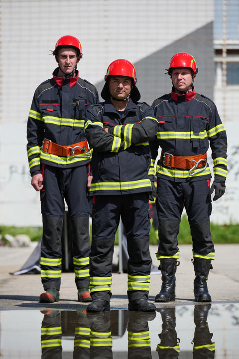 Three Firefighters in Full Gear Standing Together With Reflective Stripes and