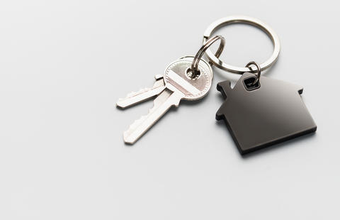Keys with house shape keychain representing home ownership