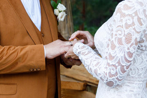 The bride slips the wedding ring onto the groom's finger during the wedding ceremony