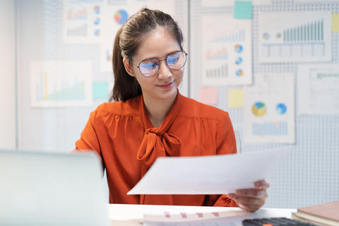Businesswoman Reviewing Documents and Considering Career Decisions