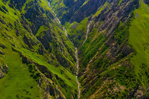 Aerial view of mountain valley with stream and rocky slopes
