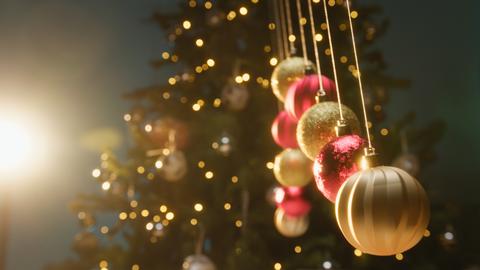 Mesmerizing Hypnotic Christmas Ball Pendulums Swing in Front of the Tree