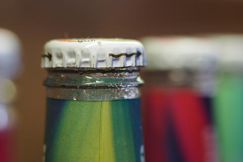 Close-up view of a bottle cap on colorful soft drink bottles
