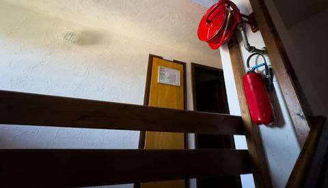 red classic fire extinguisher stands on the floor outdoors against the