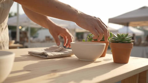 Shopper Picking Up Handmade Ceramic Tableware at an Outdoor Craft Market