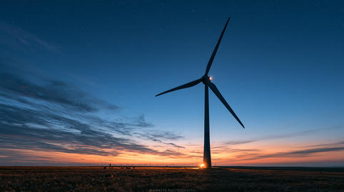 Minimalist Silhouette of a Single Wind Turbine at Sunset against Deep Blue Sky