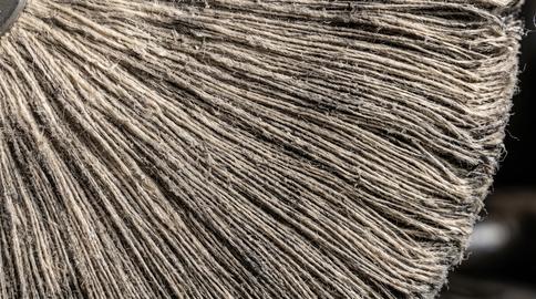 Close-up of circular polishing disc with dense coarse fiber texture and radial bristles