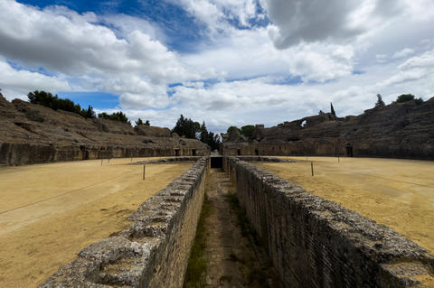 ancient roman amphitheater ruins in serene outdoor setting with stone walls and
