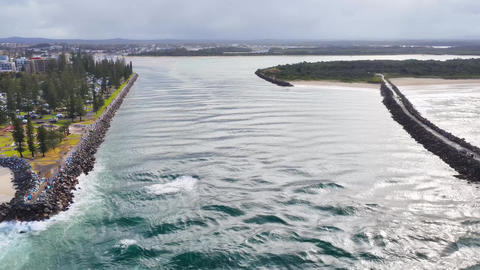 Aerial video flying backwards over the Port Macquarie channel to reveal the breakwalls