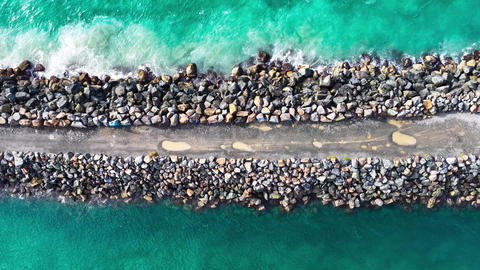 Aerial downward video of waves lapping against the North Shore breakwall at Port Macquarie