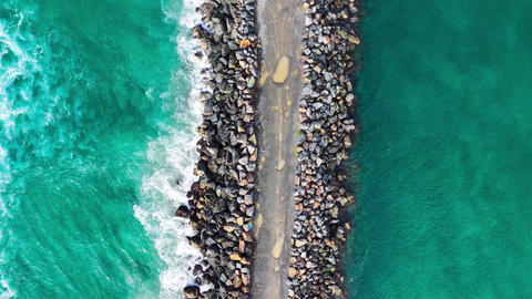 Aerial downward video of waves lapping against the North Shore breakwall at Port Macquarie