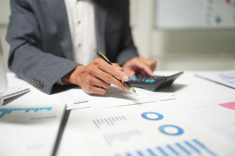 Businessperson Analyzing Financial Reports with Calculator