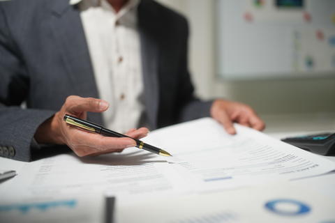 Businessman Reviewing Contract Documents With Pen