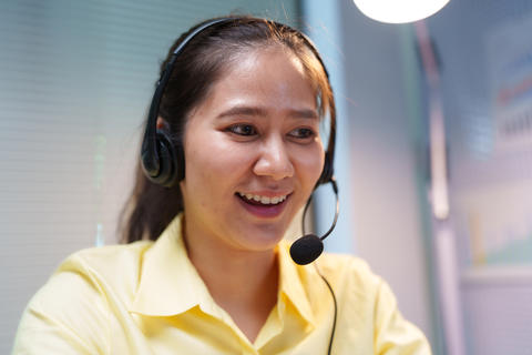 Smiling Customer Service Assistant Wearing Headset at Call Center