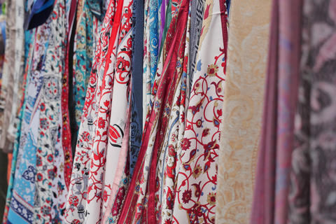Colorful fabric hanging at a market in the afternoon sun