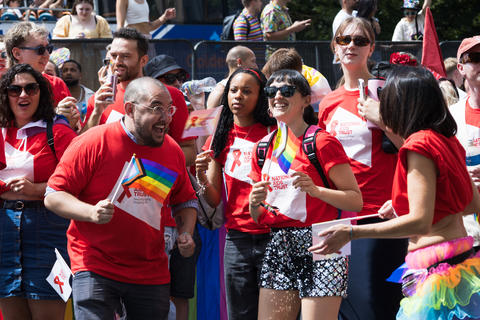 Cheering crowd waving rainbow flags at London Pride. London, UK, 29 June 2024