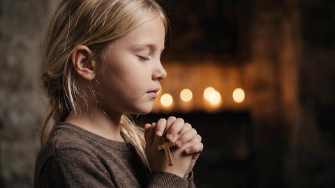 Young Girl Praying with Wooden Cross in Church Candlelight