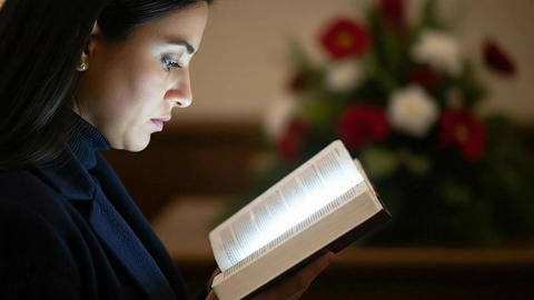 Reflected Book Illumination (Reading Prayer) Close up of a woman reading a prayer book during the se