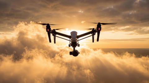 Professional Drone Flying Above Clouds at Golden Sunset for Aerial Views