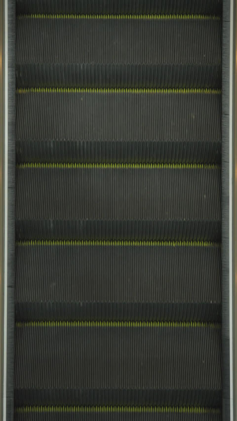 Moving metal escalator steps in top-down view