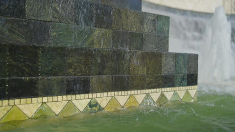 Cascading water falls over stone fountain steps