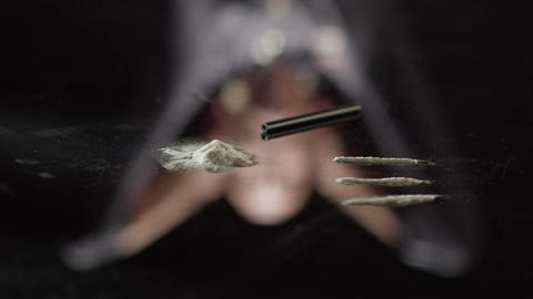 Cocaine on Black Table with Defocused Reflected Man Making a Decision