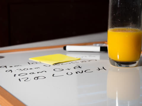Fresh orange juice at lunch break at meeting schedule on whiteboard
