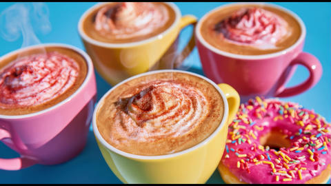 Three colorful mugs of cappuccino topped with whipped cream