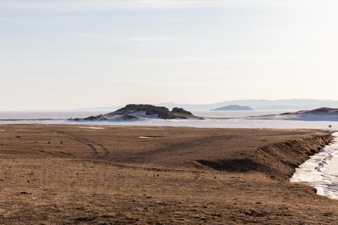 Scenic view of frozen lake shore and steppe hills in winter
