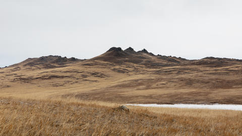 Picturesque arid hills and rocky peaks of Olkhon Island under an overcast sky