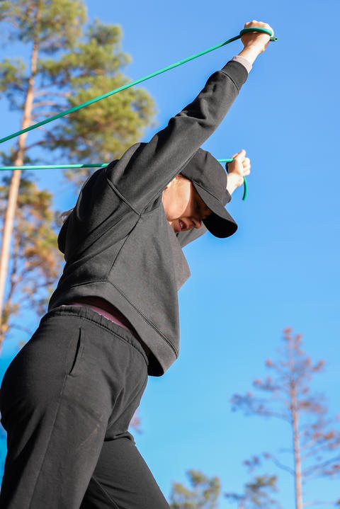 Woman Using Resistance Band for Upper Body Exercise Outdoors