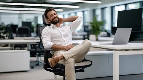 Happy businessman relaxing in office chair smiling