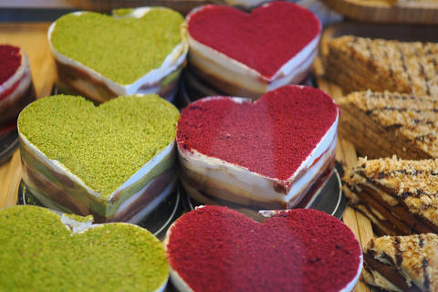 Heart-shaped cakes in a bakery with colorful layers for sale