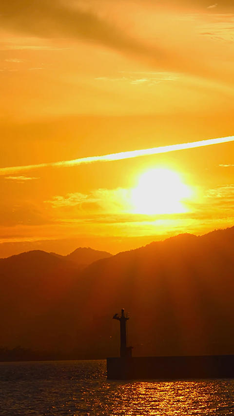 Dramatic timelapse sunset with an airplane cloud and a lighthouse in Japan,Vertical,lighthouse