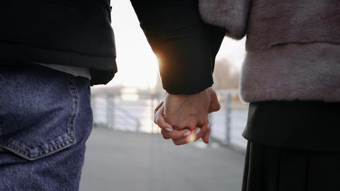 Couple Holding Hands Walking Outdoors at Sunset
