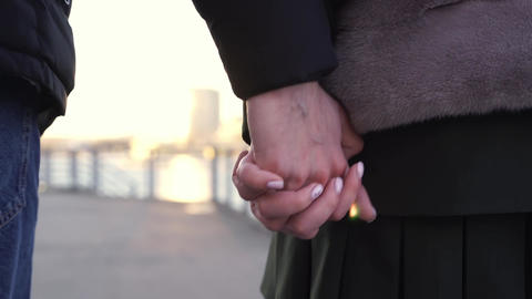 Couple Holding Hands Close-Up Walking at Sunset