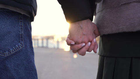 Couple Holding Hands Close-Up Walking at Sunset