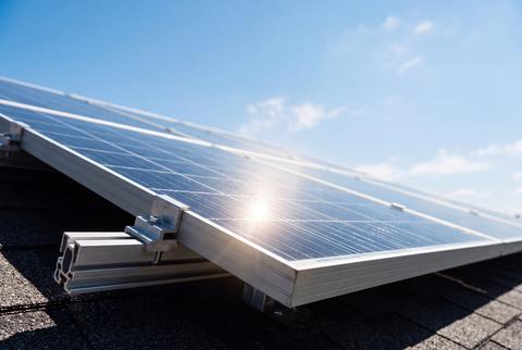 Solar Panels Installed on Roof Producing Renewable Clean Energy Under Bright Blue Sky