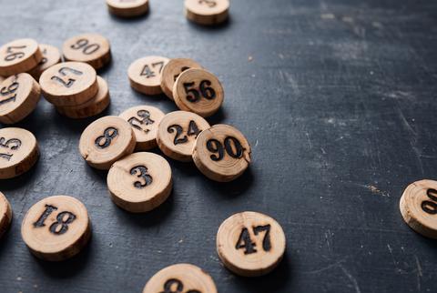 Vintage Wooden Numbered Tokens for Lotto and Board Games on Dark Surface