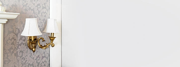 Vintage brass wall sconce on damask wallpaper