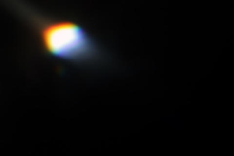 Abstract Prismatic rainbow light flare on dark background with glowing prism effect