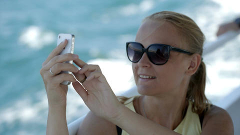 Woman making selfie with smatphone on the boat