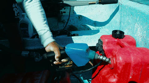 Man fueling a tank of motor boat