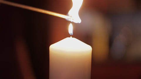 Lighting a candle with a match