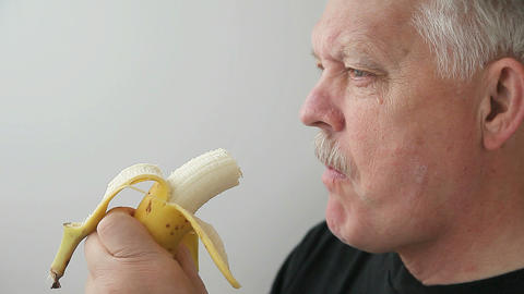 senior man eats banana