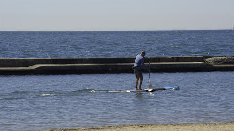 A man standup paddle boarding on the lake. 4K UHD