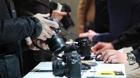 Stuff showing camera for customer inside Camera store